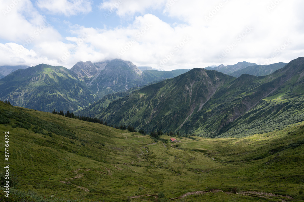 Beautiful scenic view of the Alp mountains with green grass and blue sky. Beautiful scenic view of the Alp mountains with green grass and blue sky.