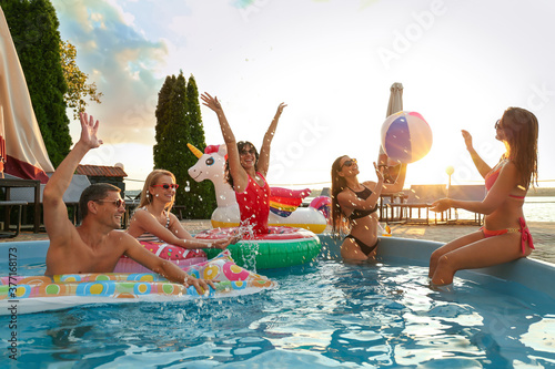 Obraz na plátně Group of happy people enjoying fun pool party