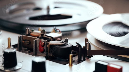 turning on vintage bobbin tape recorder, side view. grunge atmosphere close up. outmoded technology of listening to music

