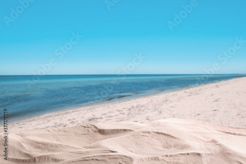 Beautiful sandy beach near sea under blue sky