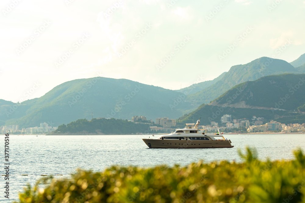 Perfect photo of a yacht against the backdrop of resort towns among the mountains, a beautiful ship with a mast Perfect photo of a yacht against the backdrop of resort towns among the mountains, a beautiful ship with a mast