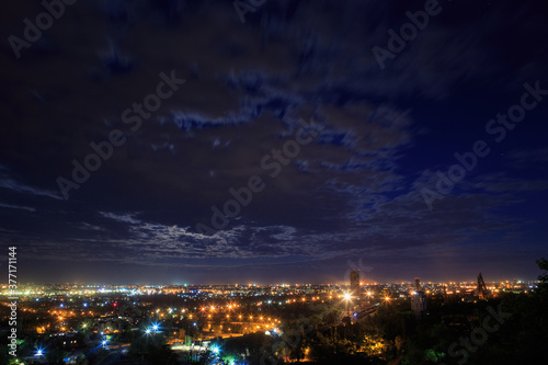 Night landscape of a big city with moving clouds