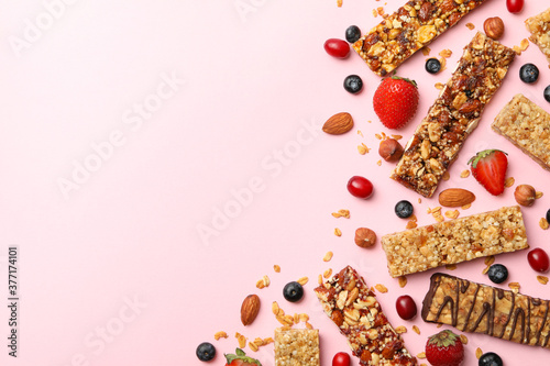Tasty granola bars on pink background, top view