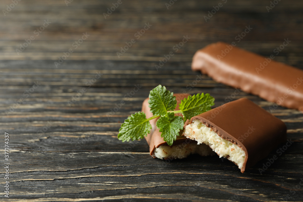 Mint and coconut bars in chocolate on wooden background