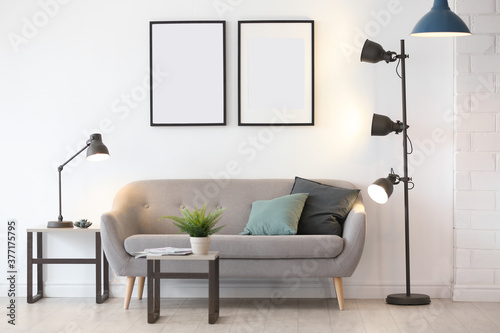 Stylish room interior with empty posters on wall. Mockup for design