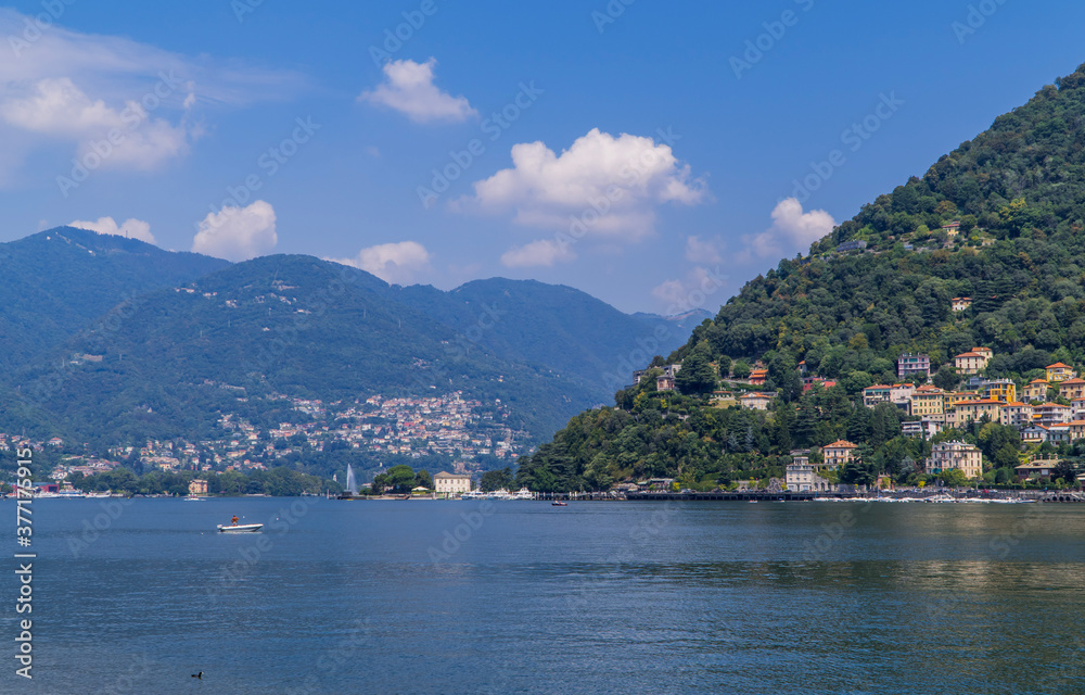 Motor boat on Lake Como, Italy with traditional Italian villas in the hills