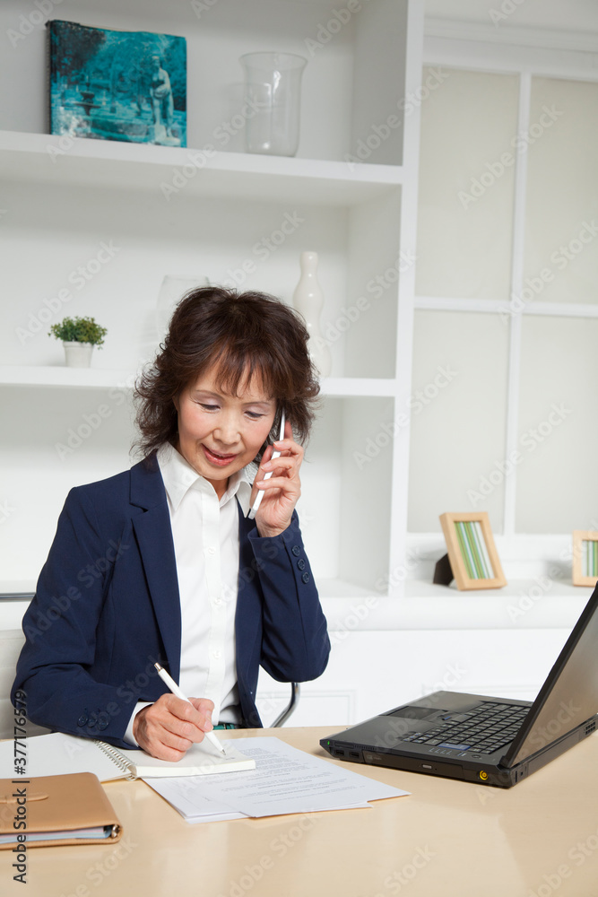 電話する女性社長 電話する女性社長