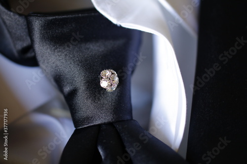 dettaglio di un gioiello nella cravatta di uno sposo