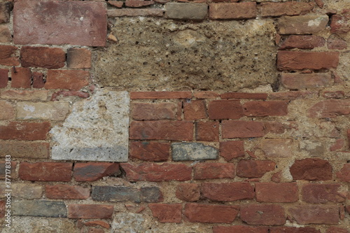 texture di un muro di cemento con mattoni rossi e sassi colorati