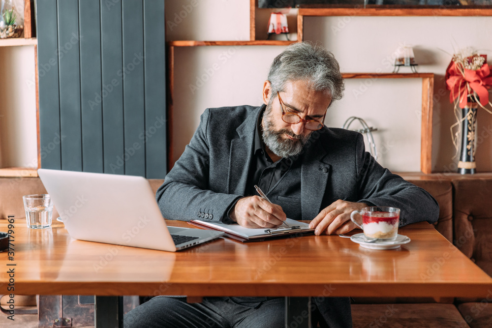 Senior businessman working at the coffee shop Senior businessman working at the coffee shop