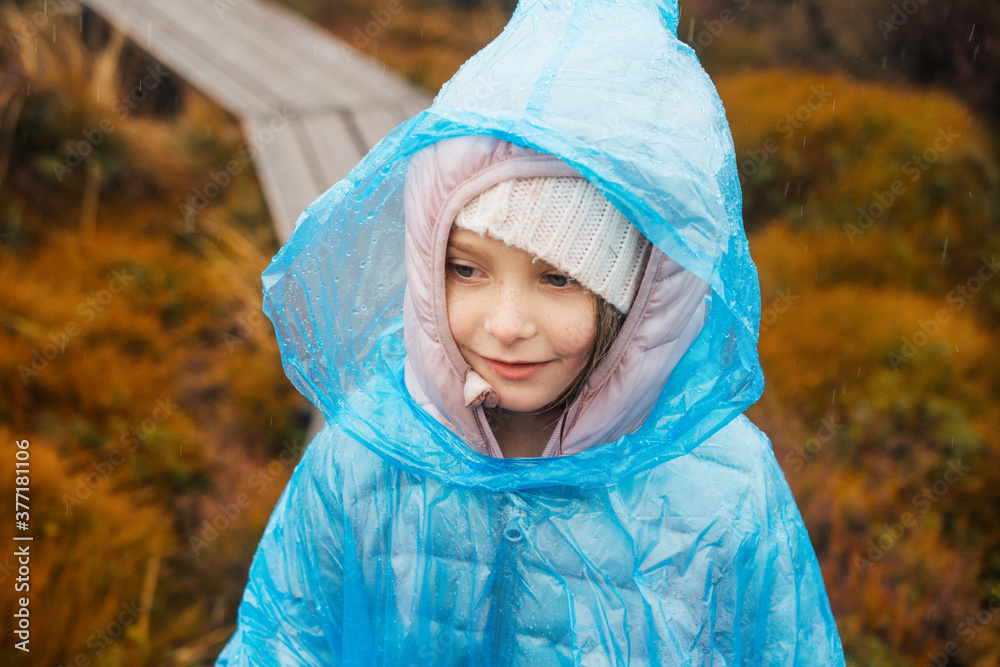 Close up of a young girl wearing a blue plastic poncho while hiking Close up of a young girl wearing a blue plastic poncho while hiking