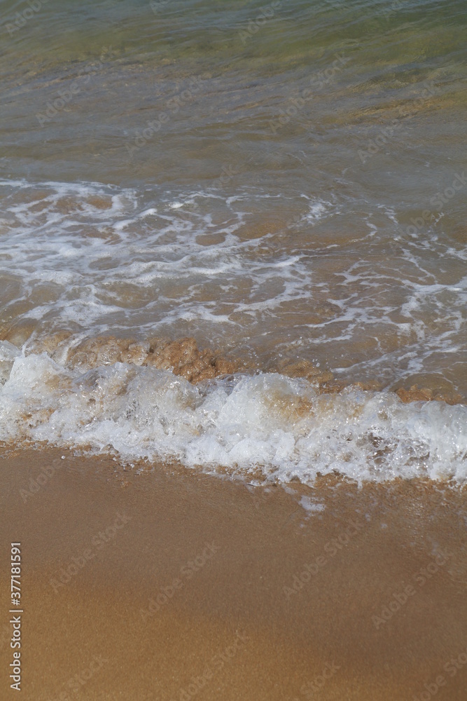 onde che si infrangono su una spiaggia di sabbia