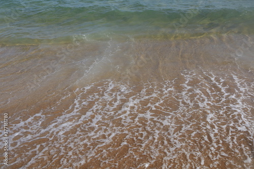 onde che si infrangono su una spiaggia di sabbia