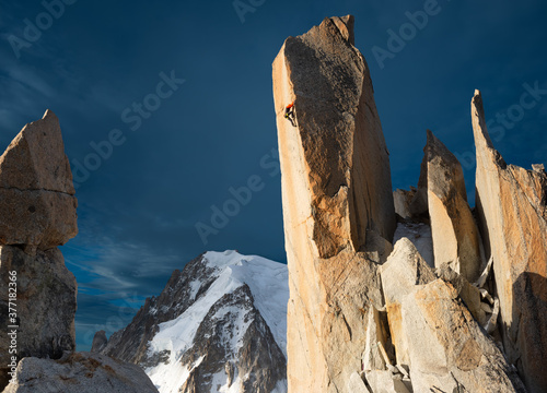 Alpine rock climber climbing in spectacular scenery