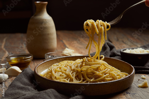 aglio e olio pasta served on a wooden table. photo