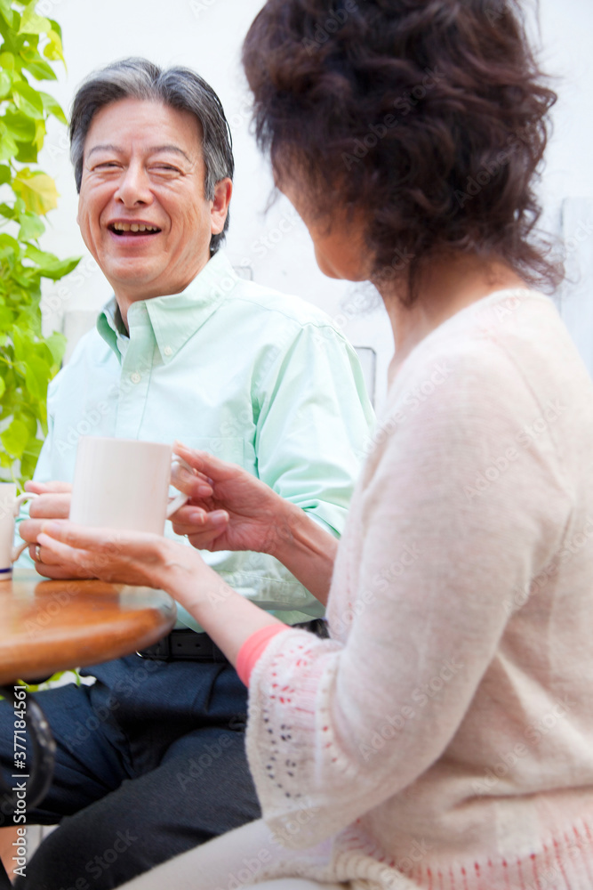 コーヒーを飲んで会話するシニア夫婦