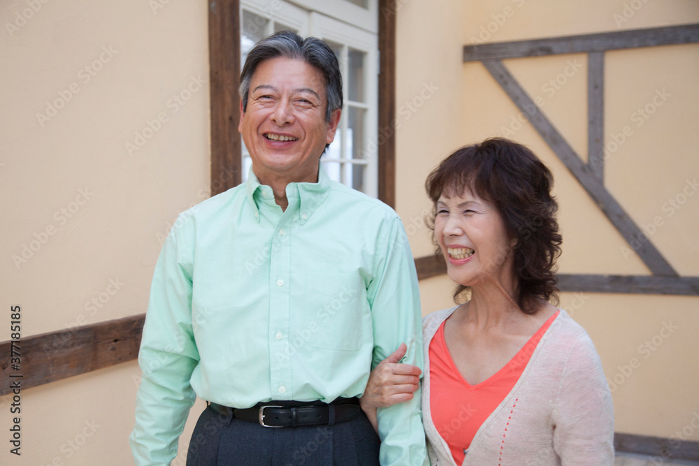 Obraz premium 腕組みをして歩くシニア夫婦