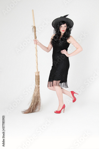 woman posing as a witch with a broom