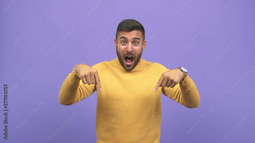 Young caucasian handsome man pointing down, smiling surprised presenting something, natural and casual Young caucasian handsome man pointing down, smiling surprised presenting something, natural and casual