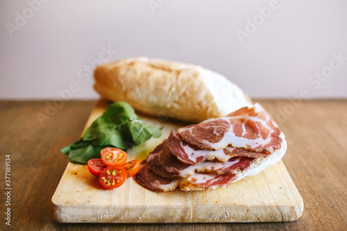 Bondiola de cerdo en tabla con pan rúcula y lechuga para sandwich