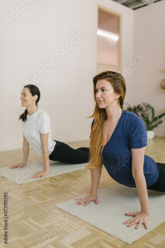 Two adult women practice yoga in a yoga studio photo