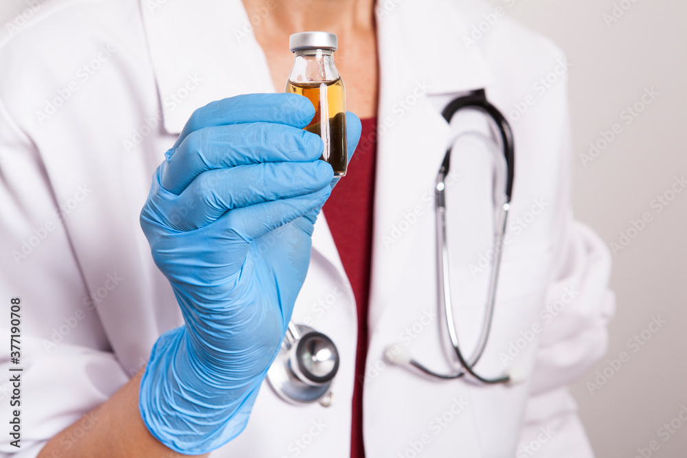 The doctor is holding a medicine bottle in her hand. The doctor is holding a medicine bottle in her hand.