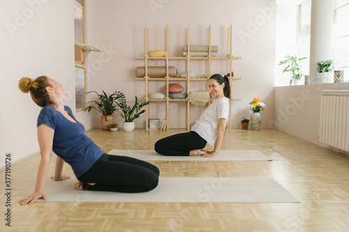 Two adult women practice yoga in a yoga studio photo