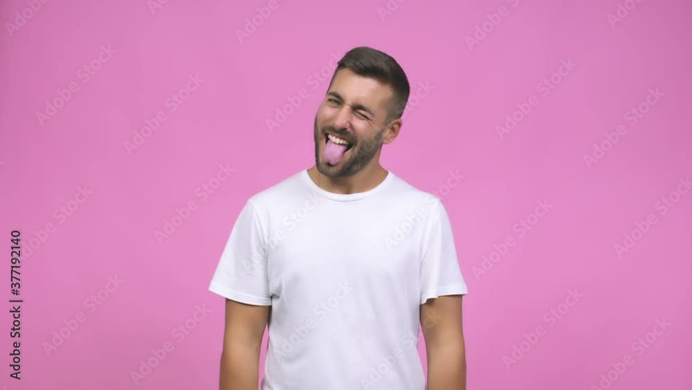Young caucasian handsome man expression of confidence and emotion, fun and friendly, showing tongue as a sign of play or fun Young caucasian handsome man expression of confidence and emotion, fun and friendly, showing tongue as a sign of play or fun
