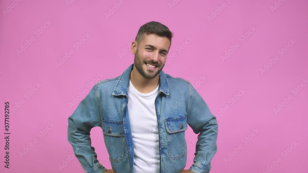 Young caucasian handsome man with hands on hips, standing, relaxed and smiling, very positive and cheerful Young caucasian handsome man with hands on hips, standing, relaxed and smiling, very positive and cheerful