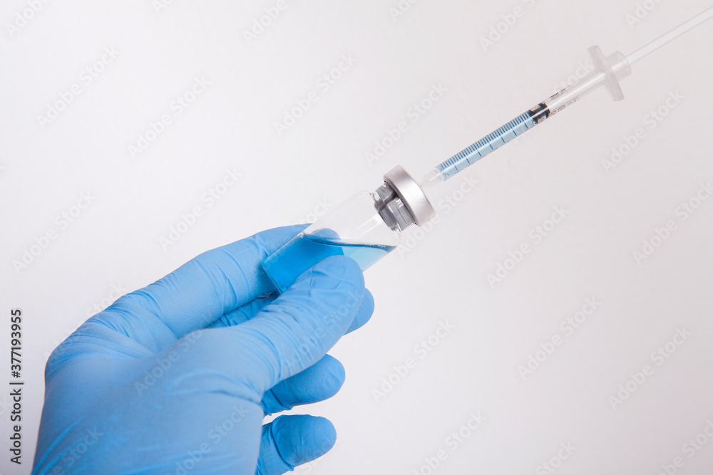 The doctor is holding a syringe and medicine bottle in his hand. The doctor is holding a syringe and medicine bottle in his hand.