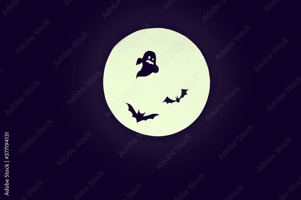 Halloween background.Round full moon, silhouettes of ghosts and bats on a uniform dark background. copy space.creepy mood