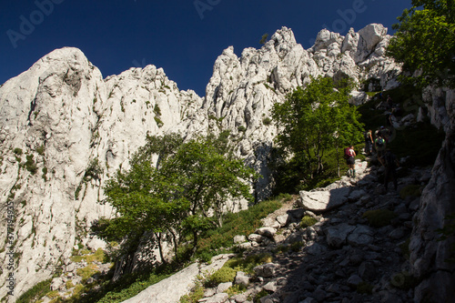 Hiking Velebit mountain in Croatia in summer, Velebit peaks Visibaba Kiza, Bacic kuk mountain rocks at Dabarski kukovi photo