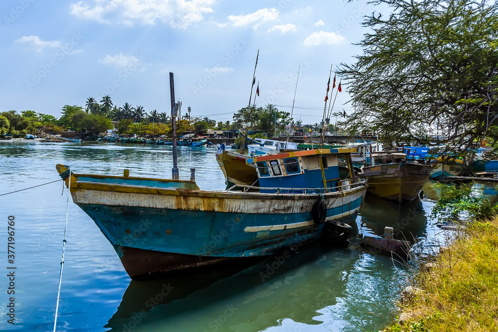 A traditional fishing boat rests on the banks of the lagoon in Negombo, Sri Lanka after an early morning fishing trip
