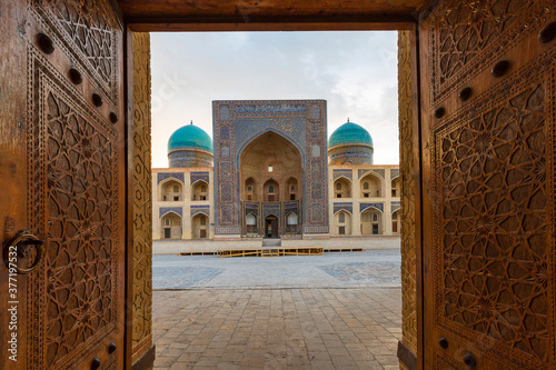 Poi Kalon madrassa, through wooden doors of the mosque in Bukhara, Uzbekistan.