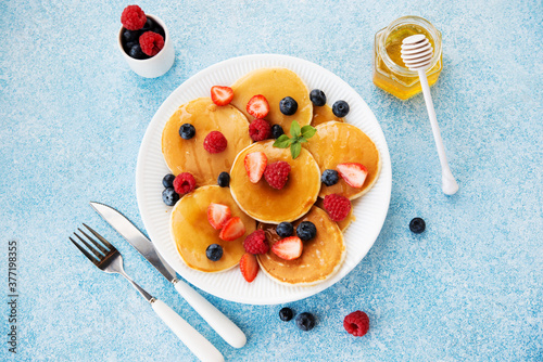 Morning pancakes with honey and berries for Breakfast or brunch, top view