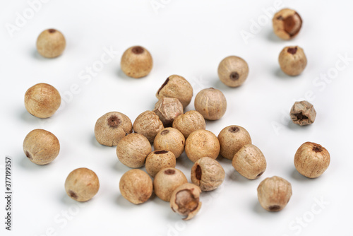 Dried white peppercorns isolated on white board, closeup detail