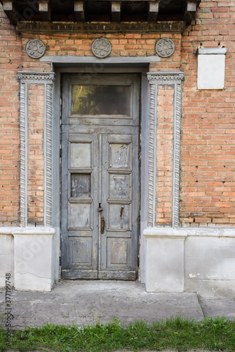 Antique doors of the main entrance to the house, with molding on the facade