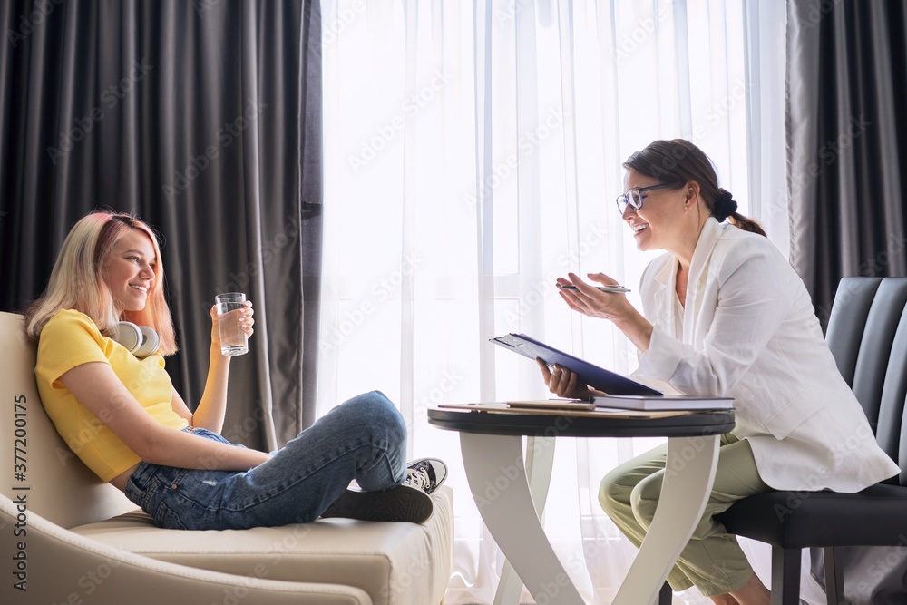 Female psychologist counseling teenage girl in office Female psychologist counseling teenage girl in office