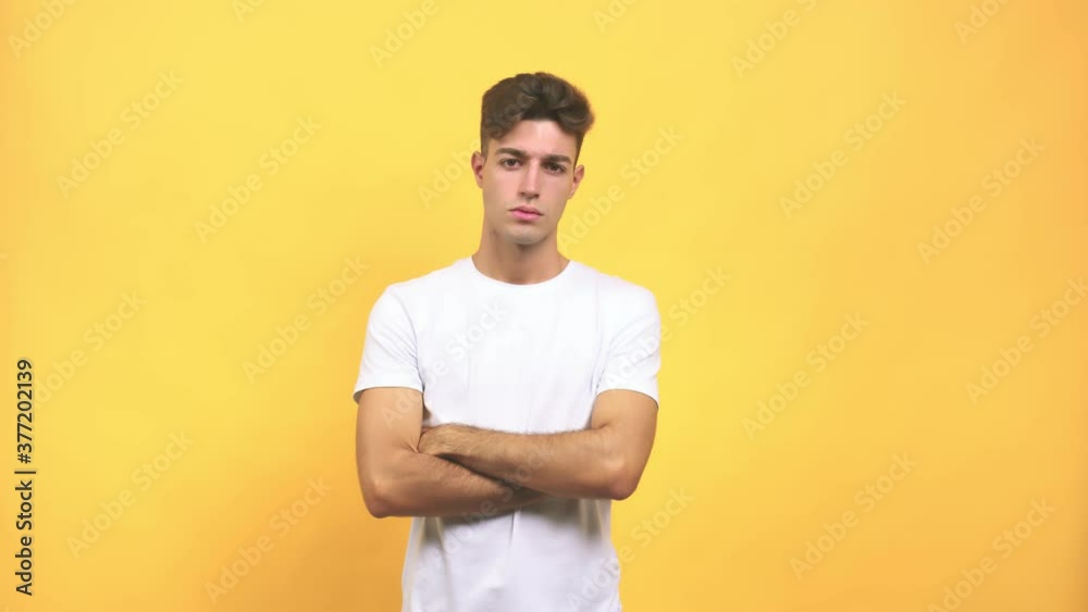 Young caucasian student man looking straight ahead, serious face, arms crossed, concept of goal and a purpose Young caucasian student man looking straight ahead, serious face, arms crossed, concept of goal and a purpose