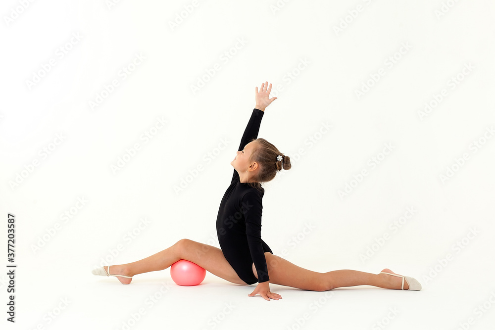 Artistic gymnast isolated on a white background. Little girl athlete