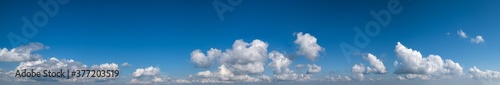 White cumulus clouds in blue sky panoramic high resolution background © wildman