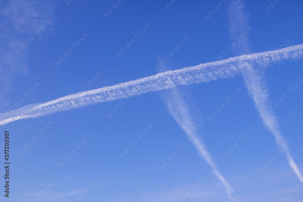 Background of clear blue sky with an inversion track crossed by two tracks Background of clear blue sky with an inversion track crossed by two tracks
