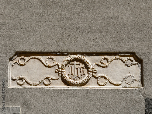 Close-up of a gray wall with a stone engraved with the religious symbol 