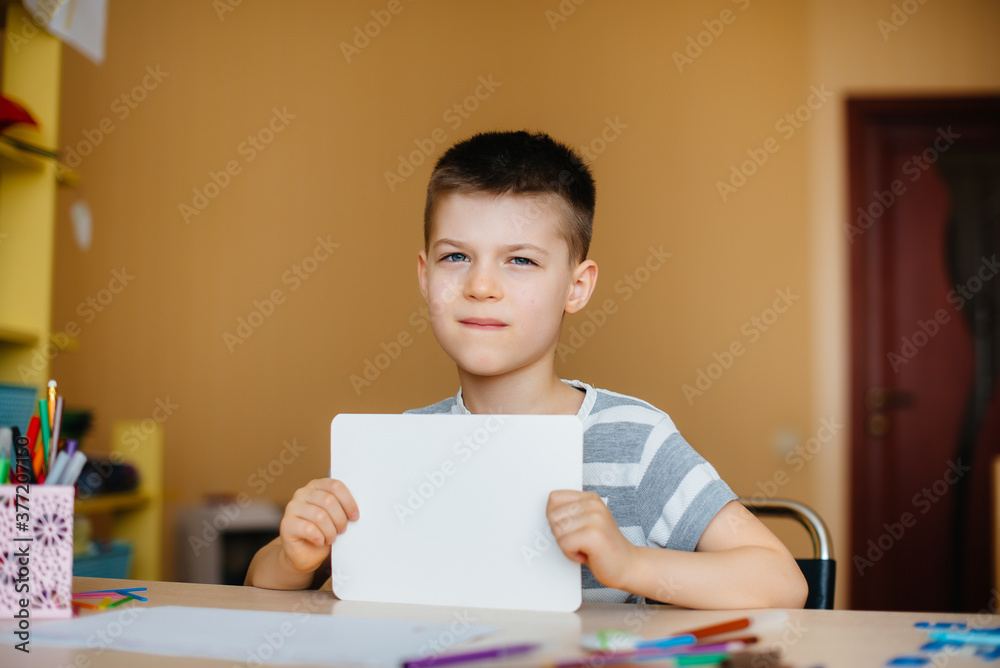 A school-age boy does homework at home. Training at school A school-age boy does homework at home. Training at school