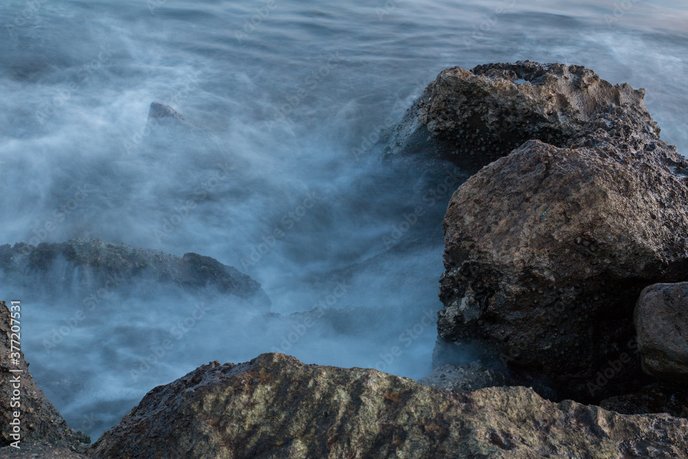 Naklejka premium lunga esposizione delle onde che si infrangono sulla scogliera