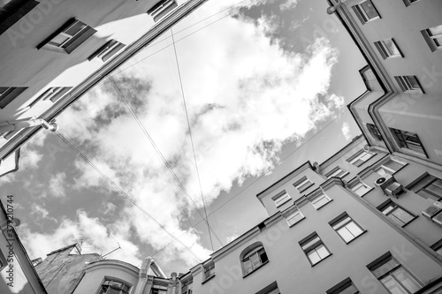 St. Petersburg, Russia, June 13, 2020. Typical for the city courtyard-well on Rubinstein street, bottom up view. A piece of sky is visible between the houses photo