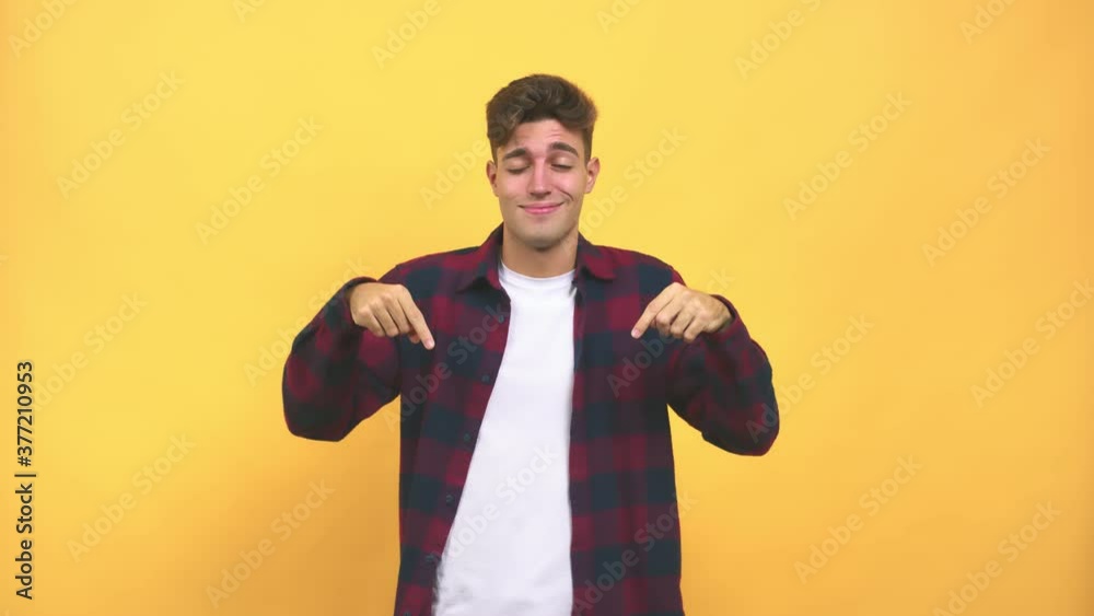 Young caucasian student man pointing down, smiling surprised presenting something, natural and casual