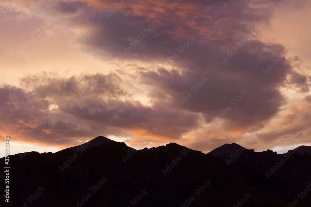 Obraz premium Enchanting sunset. View of the mountains silhouette at nightfall. Beautiful dusk colors in the sky and clouds.
