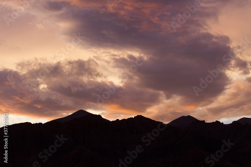 Enchanting sunset. View of the mountains silhouette at nightfall. Beautiful dusk colors in the sky and clouds. © Gonzalo