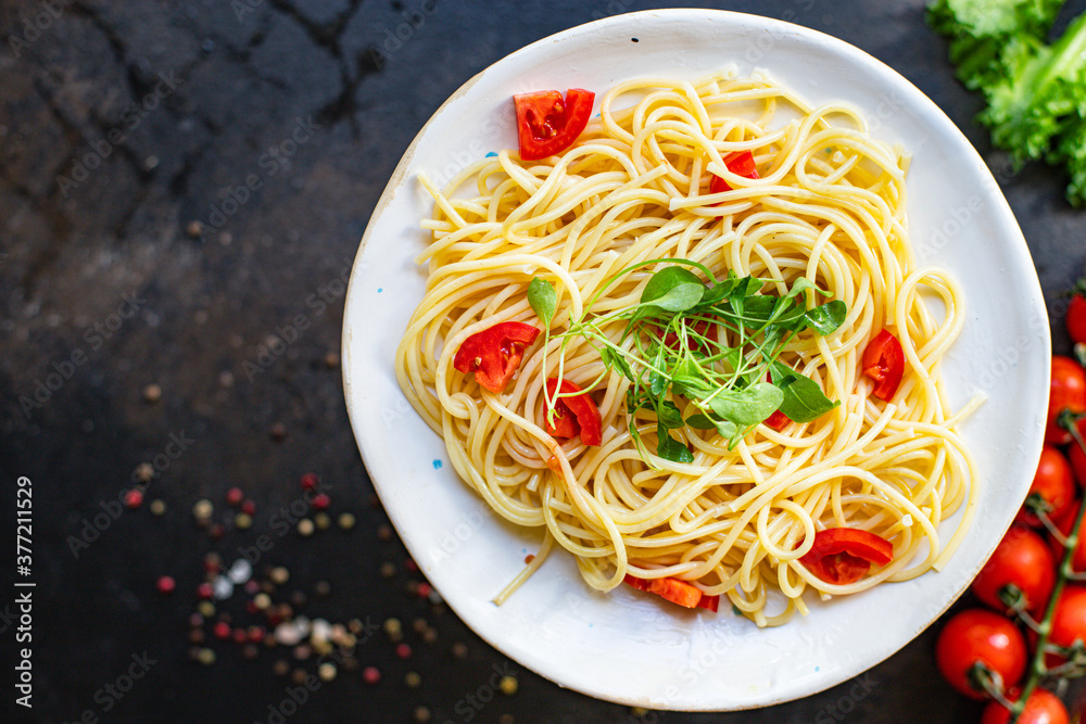 spaghetti pasta tomato salad vegetables macaroni semola durum wheat on the table serving size top view place copy space for text spaghetti pasta tomato salad vegetables macaroni semola durum wheat on the table serving size top view place copy space for text